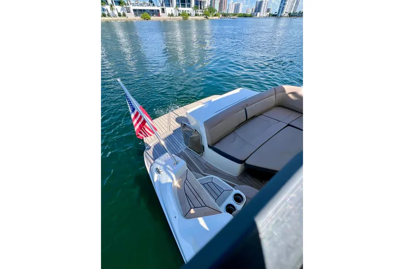 Slide: The Image of 2017 Sea Ray Sundancer 350 Coupe with American flag, docked on calm waters. - 60