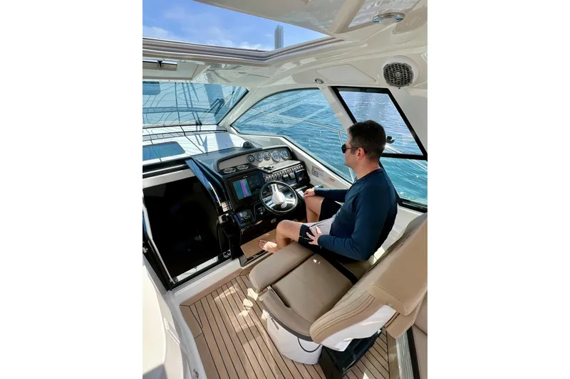 Slide: The Image of 2017 Sea Ray Sundancer 350 Coupe cruising with city skyline in the background. - 83