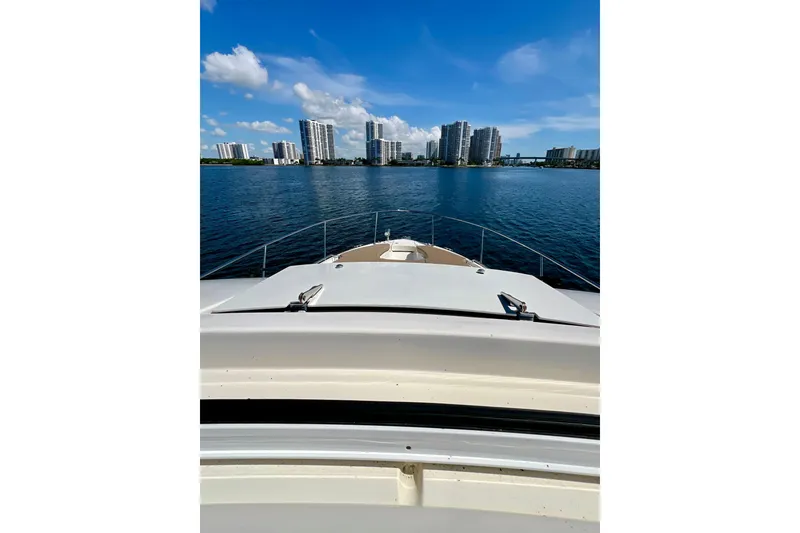 Slide: The Image of 2017 Sea Ray Sundancer 350 Coupe cruising with city skyline in the background. - 85