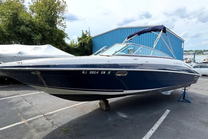 The Image of 2005 Four Winns 250 Horizon boat on display in a marina parking lot. - 0
