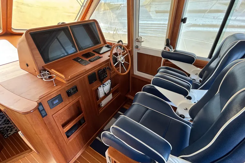 Slide: The Image of 2019 Sabre 45 Salon Express helm with dual navy seats and advanced navigation controls. - 18