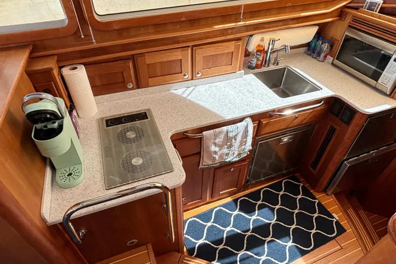 Slide: The Image of 2019 Sabre 45 Salon Express kitchen with modern appliances and wooden cabinetry. - 19