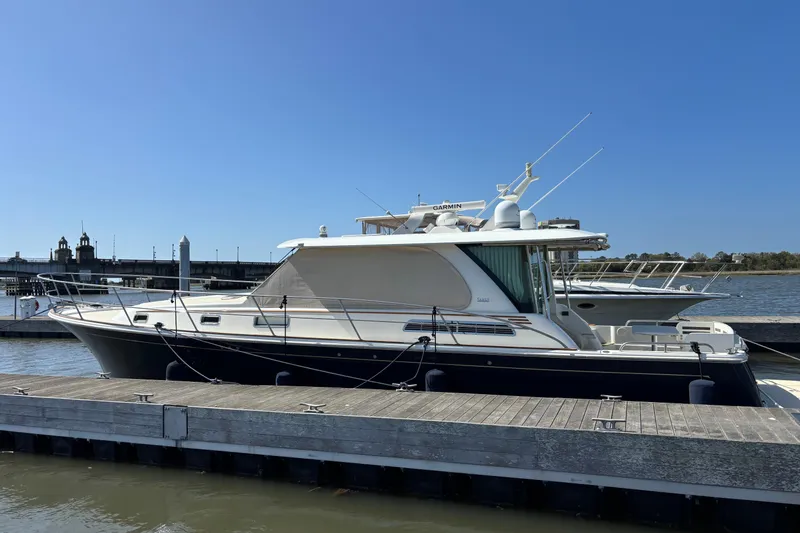 Slide: The Image of 2019 Sabre 45 Salon Express yacht docked at marina under clear blue sky. - 2