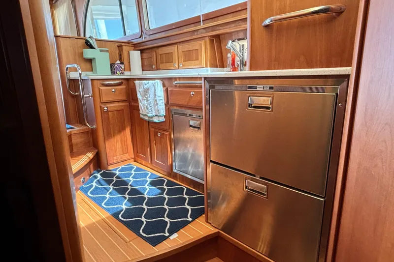 Slide: The Image of Interior of 2019 Sabre 45 Salon Express yacht kitchen with wooden cabinetry and stainless appliances. - 20