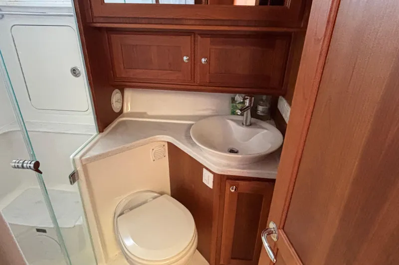 Slide: The Image of 2019 Sabre 45 Salon Express bathroom with wooden cabinetry and modern fixtures. - 23