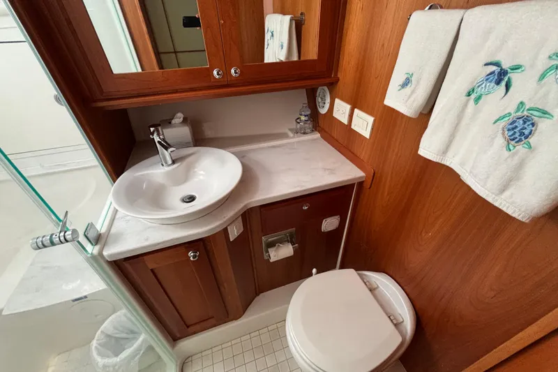 Slide: The Image of Luxurious bathroom in 2019 Sabre 45 Salon Express yacht with wooden cabinetry and turtle-themed towels. - 25
