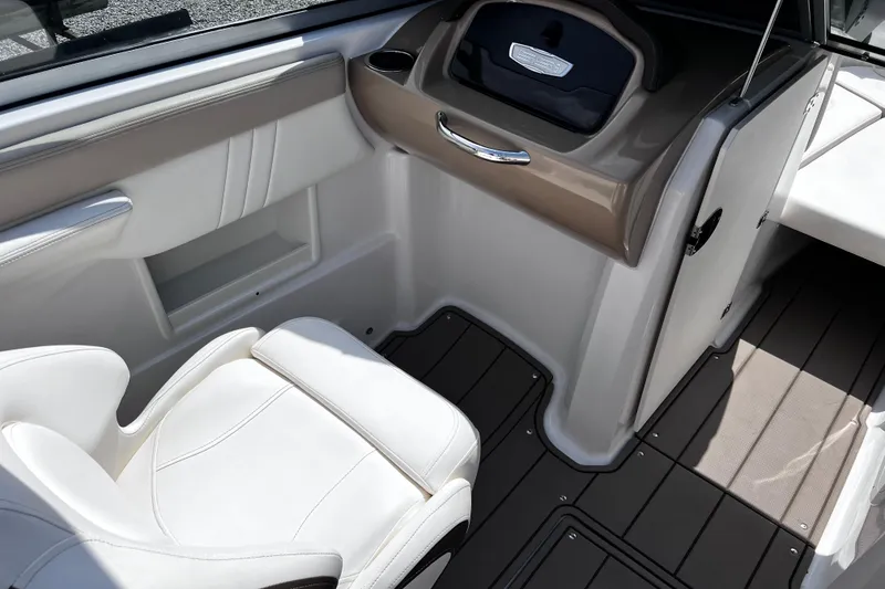 Slide: The Image of 2022 Chaparral 23 SSi boat interior with white seating and sleek dashboard design. - 11