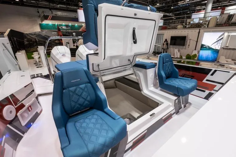 Slide: The Image of 2027 Axopar 37 Spyder boat interior with blue seats and storage compartment. - 8