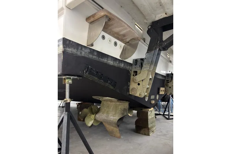 Slide: The Image of 2014 Beneteau Gran Turismo 49 yacht under maintenance, showcasing propellers and hull details. - 30