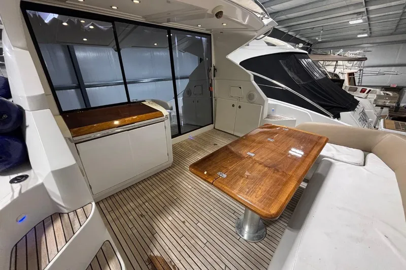 Slide: The Image of 2014 Beneteau Gran Turismo 49 yacht interior with wooden table and seating area. - 5