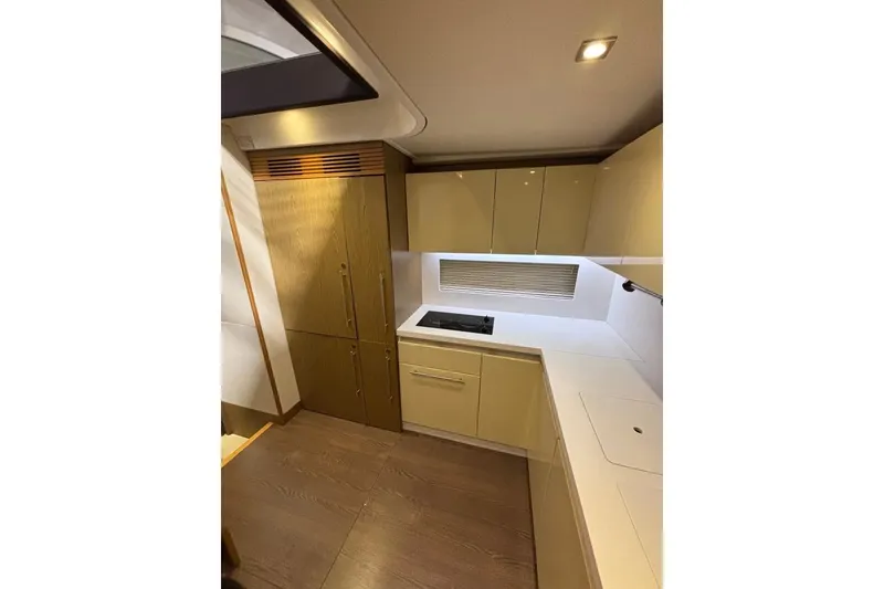 Slide: The Image of Modern kitchen interior of 2014 Beneteau Gran Turismo 49 yacht, featuring sleek cabinetry and appliances. - 50
