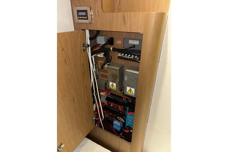 Slide: The Image of Electrical panel inside a 2014 Beneteau Gran Turismo 49 yacht, showcasing wiring and components. - 58