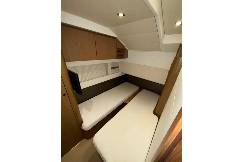 Slide: The Image of 2014 Beneteau Gran Turismo 49 cabin with twin beds and modern wood paneling. - 59