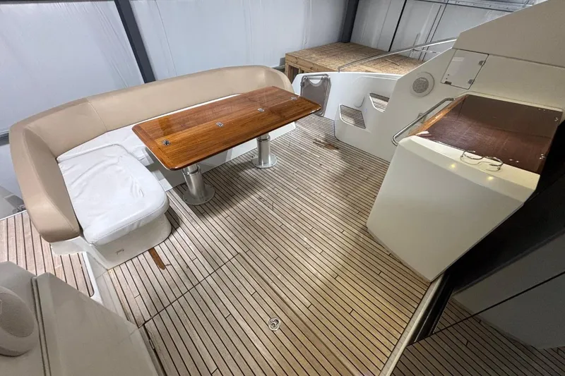Slide: The Image of 2014 Beneteau Gran Turismo 49 yacht interior with wooden table and cushioned seating. - 6