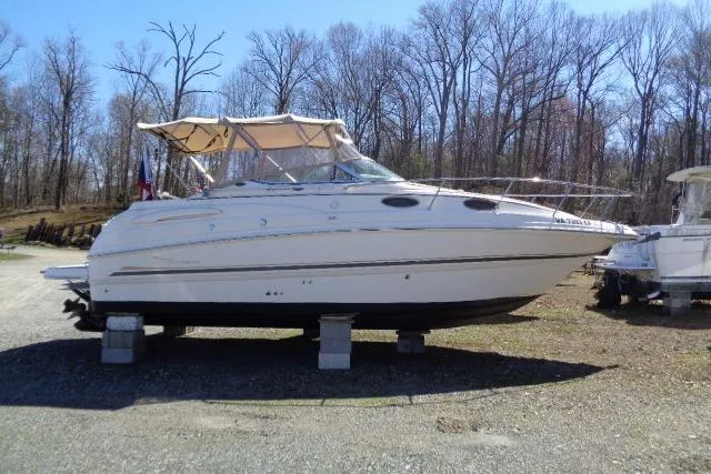 The Image of 2002 Chaparral Signature 260 boat on blocks, surrounded by trees. - 0