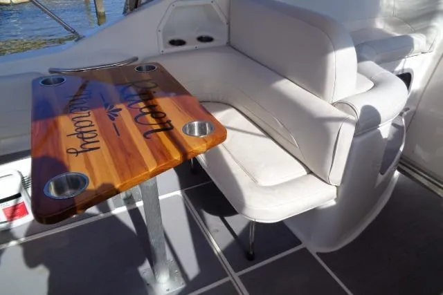 Slide: The Image of 2002 Chaparral Signature 260 boat interior with wooden table and white seating. - 10