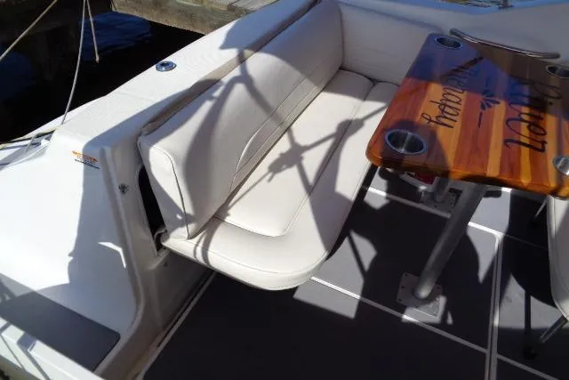 Slide: The Image of 2002 Chaparral Signature 260 boat interior with white seating and wooden table. - 13
