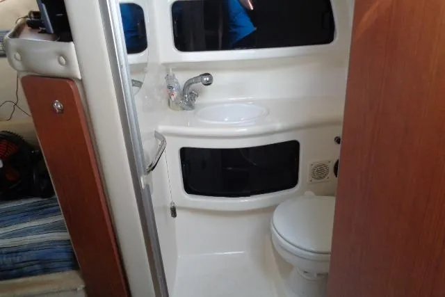 Slide: The Image of 2002 Chaparral Signature 260 boat bathroom with sink, mirror, and toilet. - 19