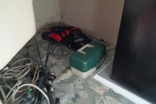 Slide: The Image of Storage area in a 2002 Chaparral Signature 260 with fishing gear and life jacket. - 22