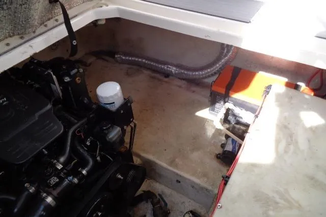 Slide: The Image of Engine compartment of a 2002 Chaparral Signature 260 boat, showing mechanical components and battery. - 25
