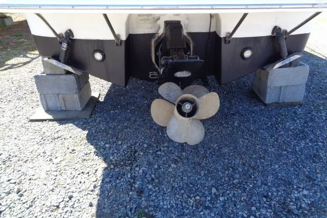 Slide: The Image of 2002 Chaparral Signature 260 boat stern with propeller on gravel. - 26