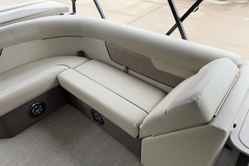 Slide: The Image of 2021 Crest Classic LX 200 L boat interior with beige seating and built-in speakers. - 12