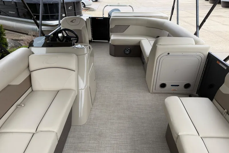 Slide: The Image of 2021 Crest Classic LX 200 L pontoon boat interior with beige seating and steering console. - 4