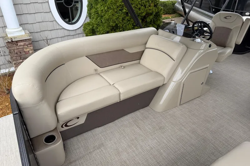 Slide: The Image of 2021 Crest Classic LX 200 L pontoon boat interior with beige seating and steering console. - 6