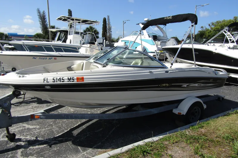 The Image of 2004 Sea Ray 180 Sport boat on trailer in marina setting. - 0