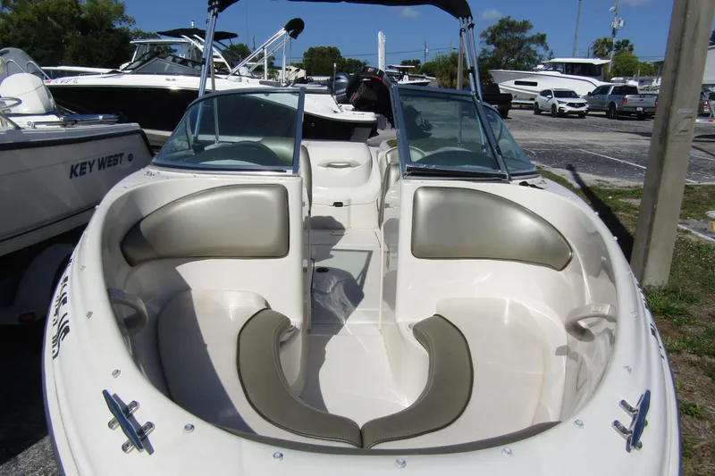 Slide: The Image of 2004 Sea Ray 180 Sport boat with open bow seating, parked in a marina. - 4