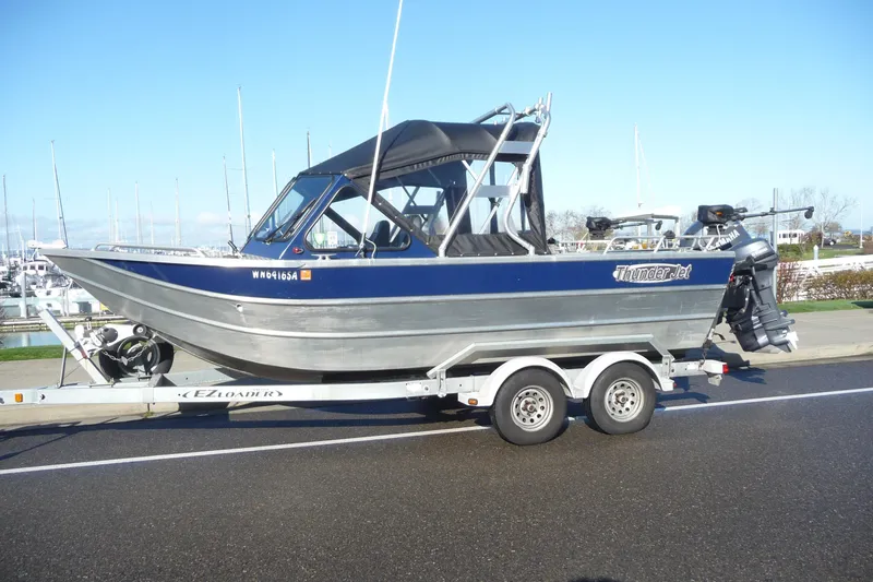 The Image of 2013 Thunder Jet 21 Luxor OB boat on trailer, parked near marina. - 0