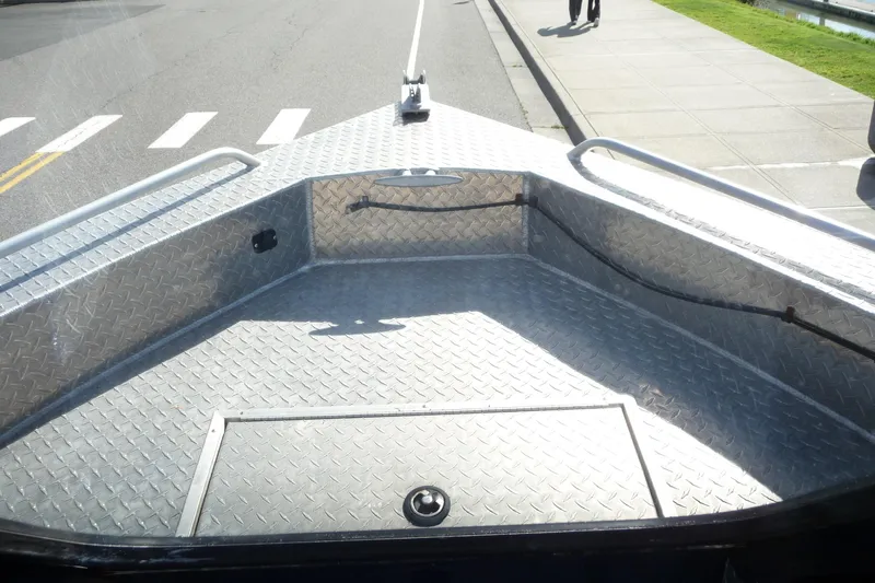 Slide: The Image of 2013 Thunder Jet 21 Luxor OB boat with diamond plate deck, parked on street. - 12