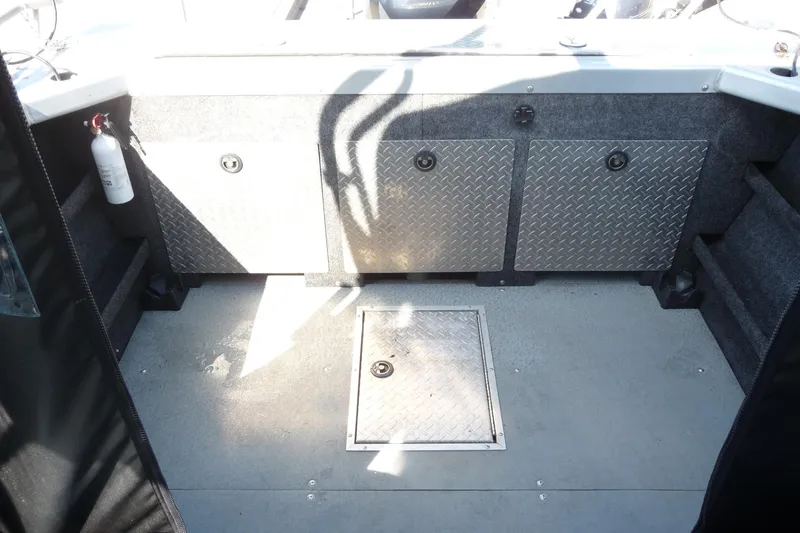 Slide: The Image of Interior of 2013 Thunder Jet 21 Luxor OB boat with storage compartments and fire extinguisher. - 14