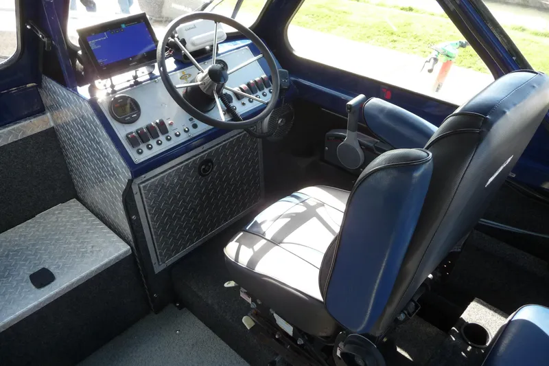 Slide: The Image of Interior of a 2013 Thunder Jet 21 Luxor OB boat with steering wheel and control panel. - 8