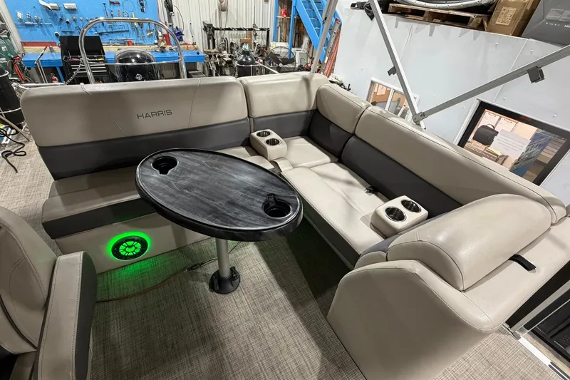 Slide: The Image of 2021 Harris Cruiser 210 boat interior with beige seating and a round table. - 12