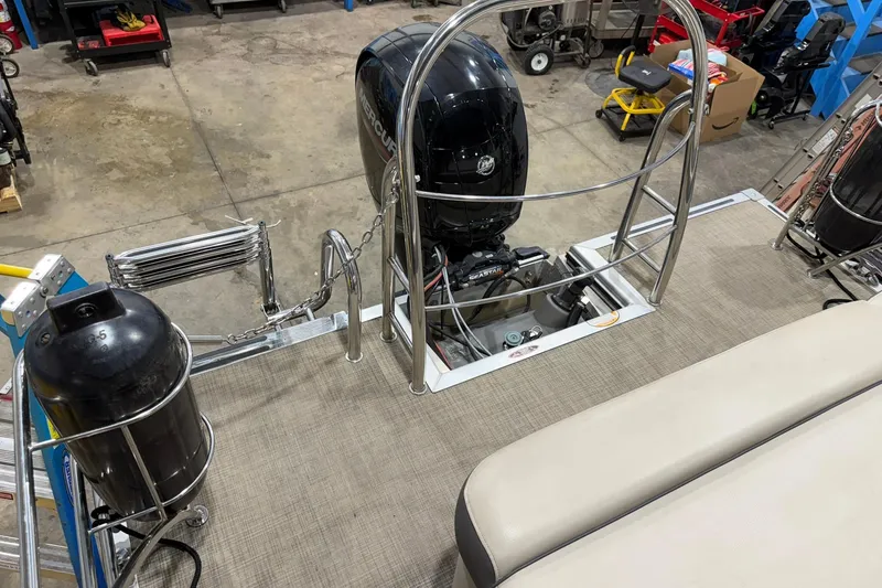 Slide: The Image of 2021 Harris Cruiser 210 boat with Mercury outboard motor in a workshop setting. - 13