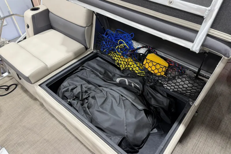 Slide: The Image of Storage compartment in a 2021 Harris Cruiser 210 boat with gear and nets. - 15
