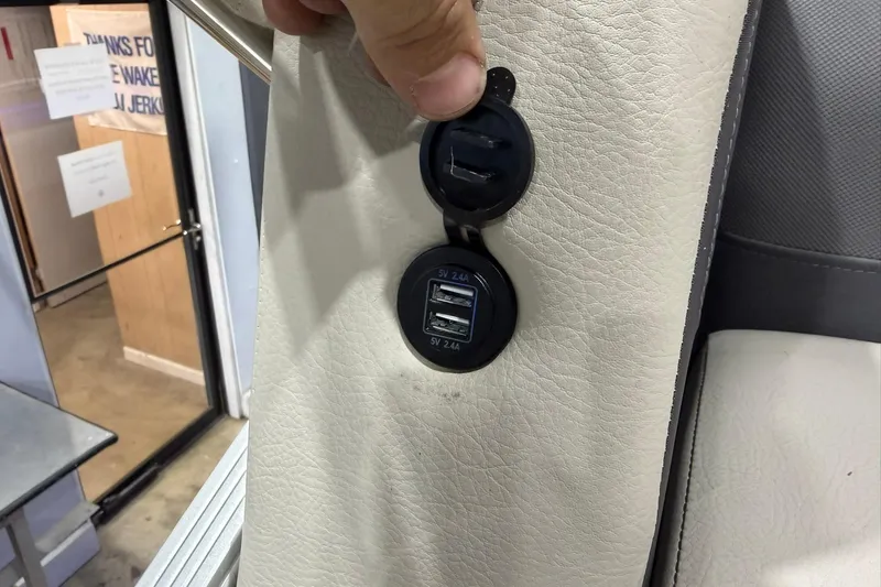 Slide: The Image of USB charging ports on 2021 Harris Cruiser 210 boat's leather interior. - 16
