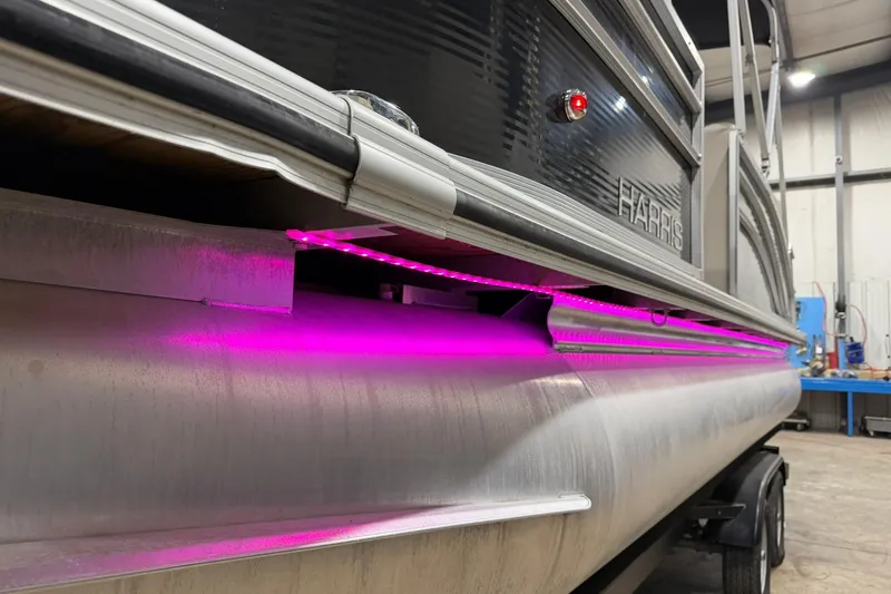 Slide: The Image of 2021 Harris Cruiser 210 pontoon boat with vibrant pink LED underglow lighting. - 17