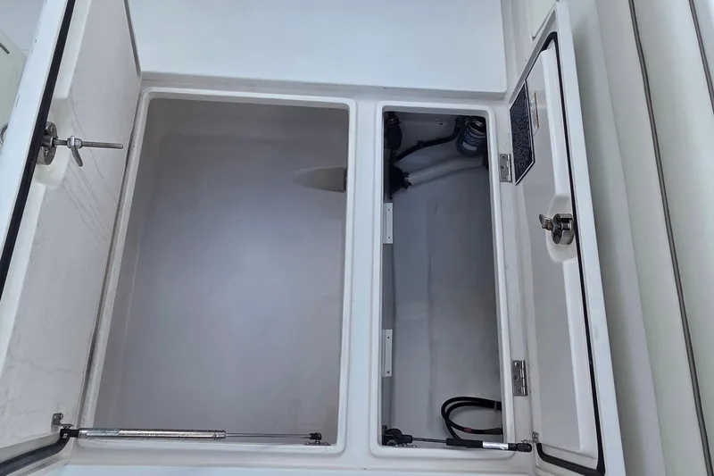Slide: The Image of Open storage compartments on a 2014 Jupiter 26 FS boat, showcasing interior space. - 13