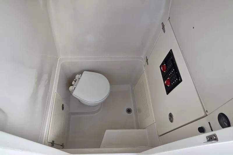 Slide: The Image of 2014 Jupiter 26 FS boat interior with compact marine toilet and control panel. - 19