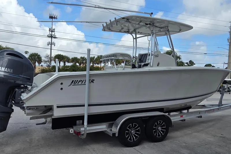 Slide: The Image of 2014 Jupiter 26 FS boat on trailer with Yamaha engine, parked outdoors. - 20