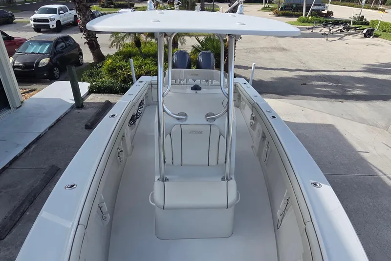 Slide: The Image of 2014 Jupiter 26 FS boat with T-top and center console, parked on concrete. - 5