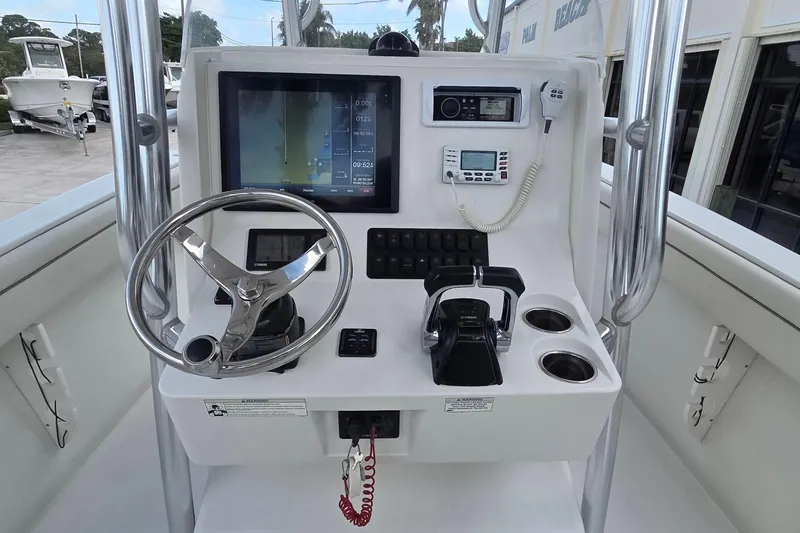 Slide: The Image of 2014 Jupiter 26 FS boat console with steering wheel, controls, and navigation display. - 6