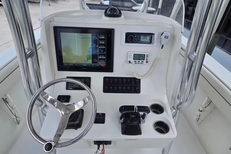 Slide: The Image of Control panel of a 2014 Jupiter 26 FS boat with steering wheel and navigation equipment. - 8