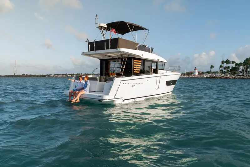 Slide: The Image of 2026 Beneteau Swift Trawler 37 Fly cruising on open water with passengers. - 18