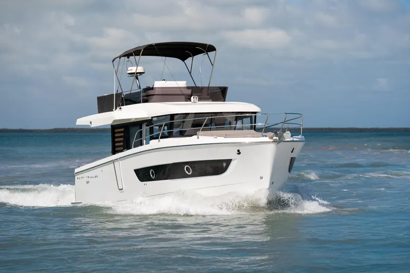 Slide: The Image of 2026 Beneteau Swift Trawler 37 Fly cruising on open water under a clear sky. - 21