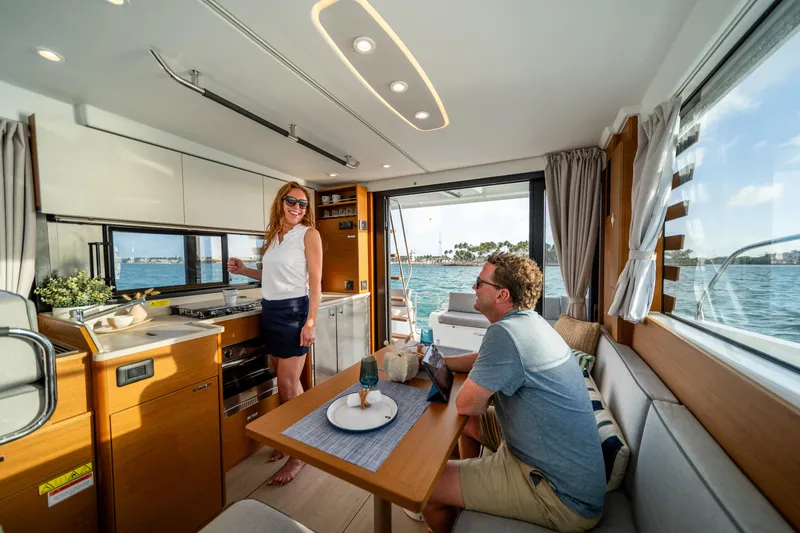 Slide: The Image of Interior of 2026 Beneteau Swift Trawler 37 Fly with people enjoying the cabin. - 6