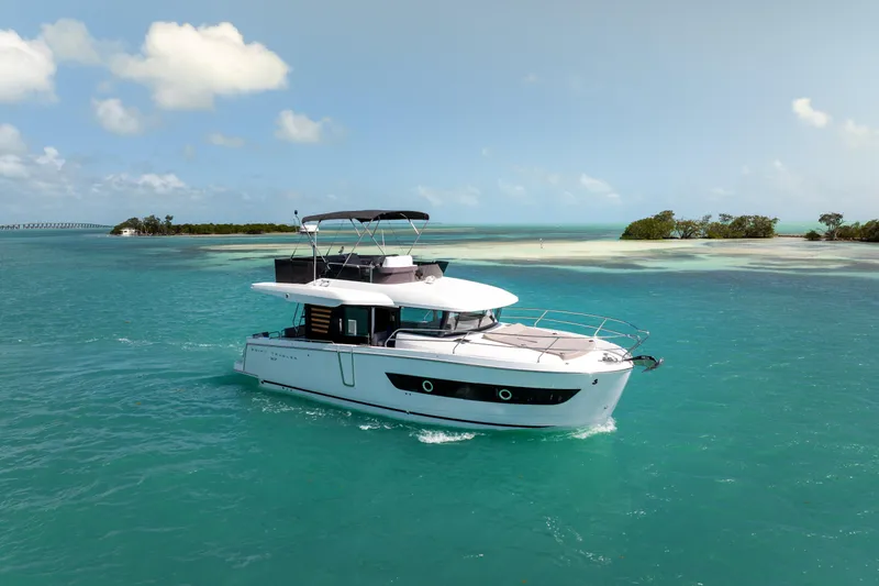 Slide: The Image of 2026 Beneteau Swift Trawler 37 Fly cruising on turquoise waters. - 2