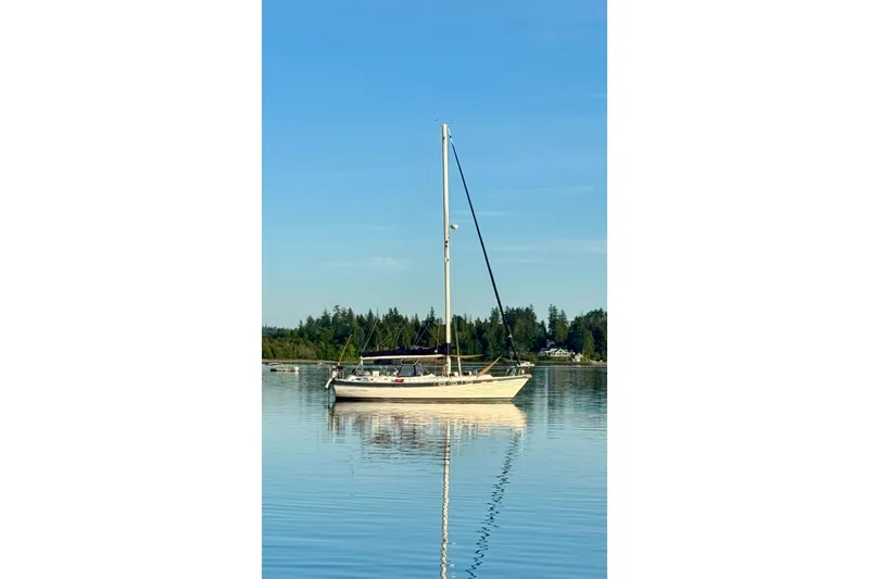 The Image of 1987 Morgan Classic 41 Center Cockpit sailboat on calm water, clear sky background. - 1